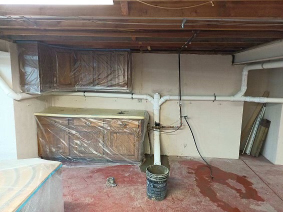 Basement plumbing for house with damaged pipes under floor